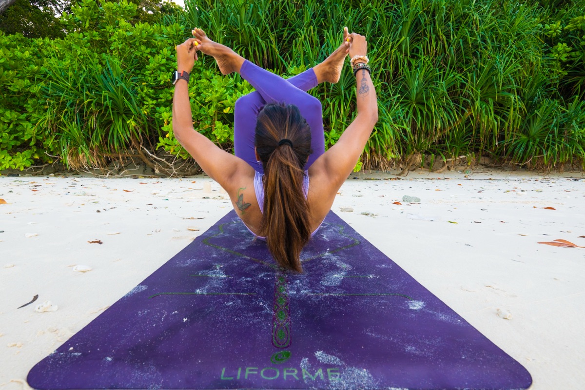 Side stretch with yoga wheel in studio